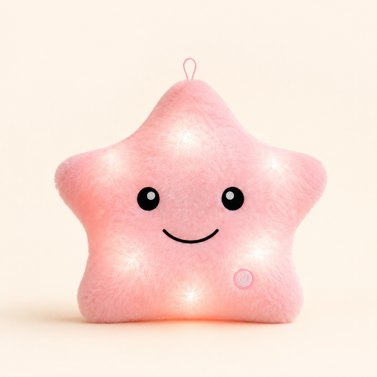 Pink Glowshie light-up star pillow glowing softly with a cute smiling face.