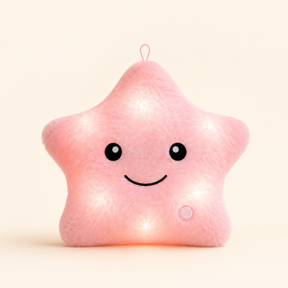 Pink Glowshie light-up star pillow glowing softly with a cute smiling face.