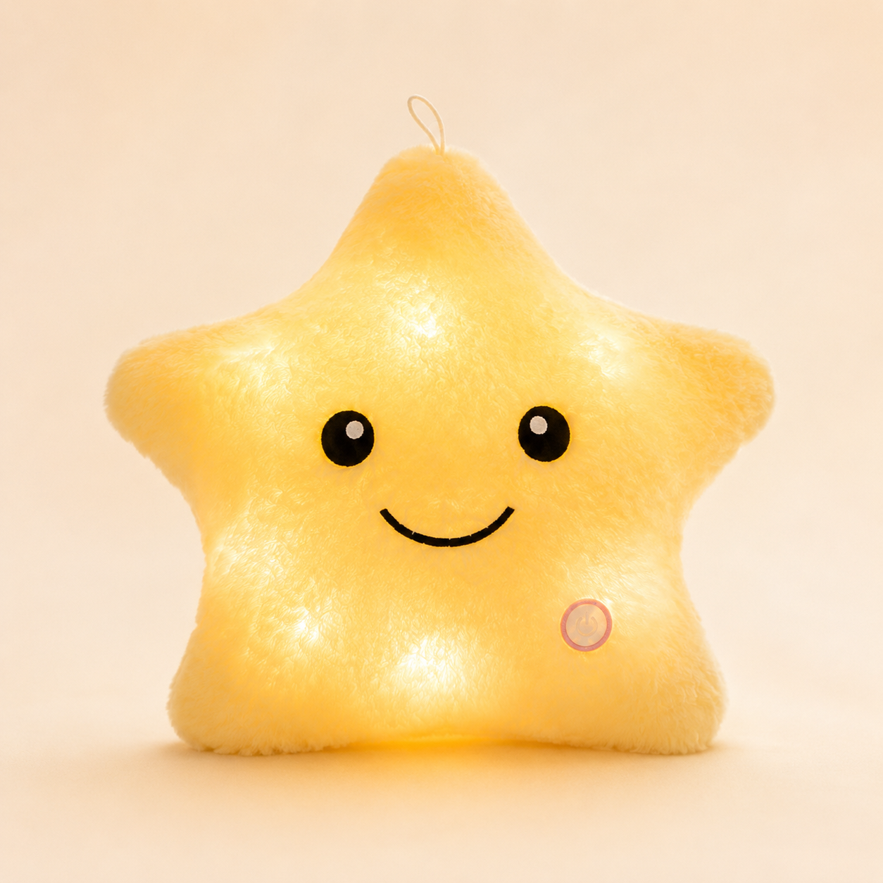 ellow Glowshie light-up star pillow glowing warmly with a cute smiling face.