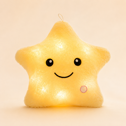 ellow Glowshie light-up star pillow glowing warmly with a cute smiling face.